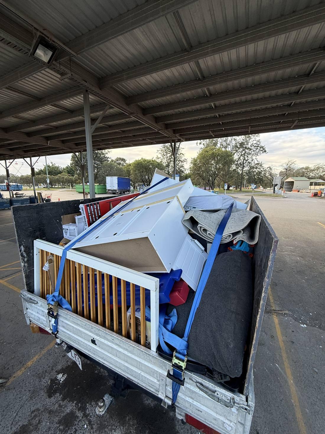 Trailer loaded with furniture and household waste, strapped down